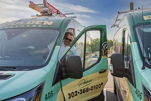Boulden Brothers electrician arriving on-site in a branded service van ready for an outdoor lighting installation.